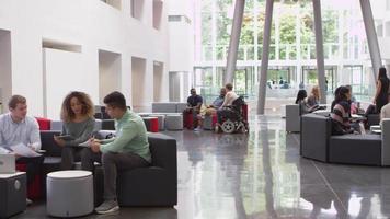 grupos de estudiantes socializando en un vestíbulo de la universidad, filmado en r3d video