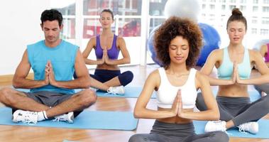 aula de ioga sentados em pose de lótus juntos