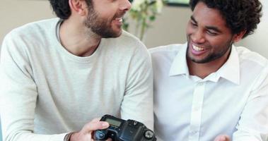 Gay couple looking pictures together on their camera
