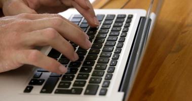 Close up view of masculine hands typing on a laptop video