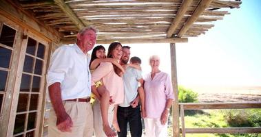 tre generationens familj som står tillsammans en sommardag