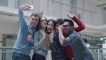 grupp unga multietniska studenter använder en surfplatta på ett universitet. video