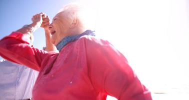 Foto sincera de una feliz pareja de ancianos jubilados en la playa riendo juntos