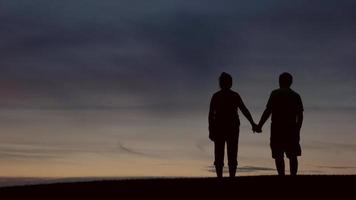 Silhouette of couple holding hands.
