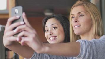 två vänner tar en selfie på ett kafé video