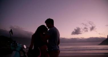 liebevolles Paar und ihr Roller am Strand video
