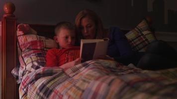 en mamma som läser sin son en bok före sängen video
