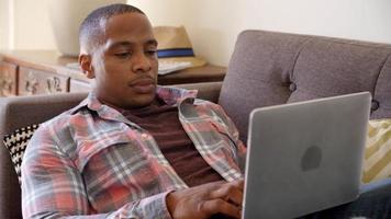 Man Relaxing On Sofa At Home Using Laptop video