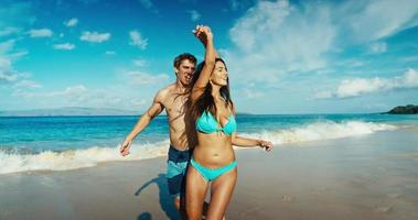 par som håller händer som går ner tropisk strand i ultrarapid video