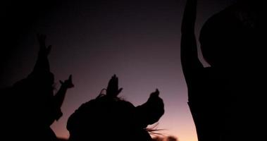 festejando adolescentes dançando e sua silhueta contra o céu crepuscular