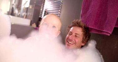 pai moderno tomando banho de espuma com filha pequena video
