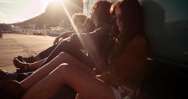 amigos hipster descansando fora de sua van ao pôr do sol