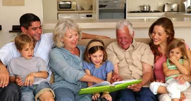Extended family looking at photo album together on couch video