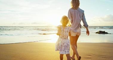 mor och dotter som leker på stranden