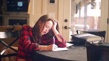 jonge tiener huiswerk aan de keukentafel en om hulp te vragen