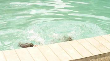 junge hispanische Mädchen halten den Atem unter Wasser in einem Pool an