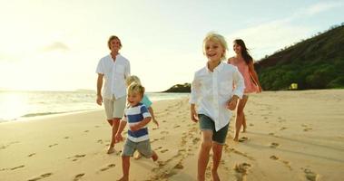familia feliz en la playa al atardecer