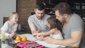 Caring same-sex parents teaching daughters to draw video