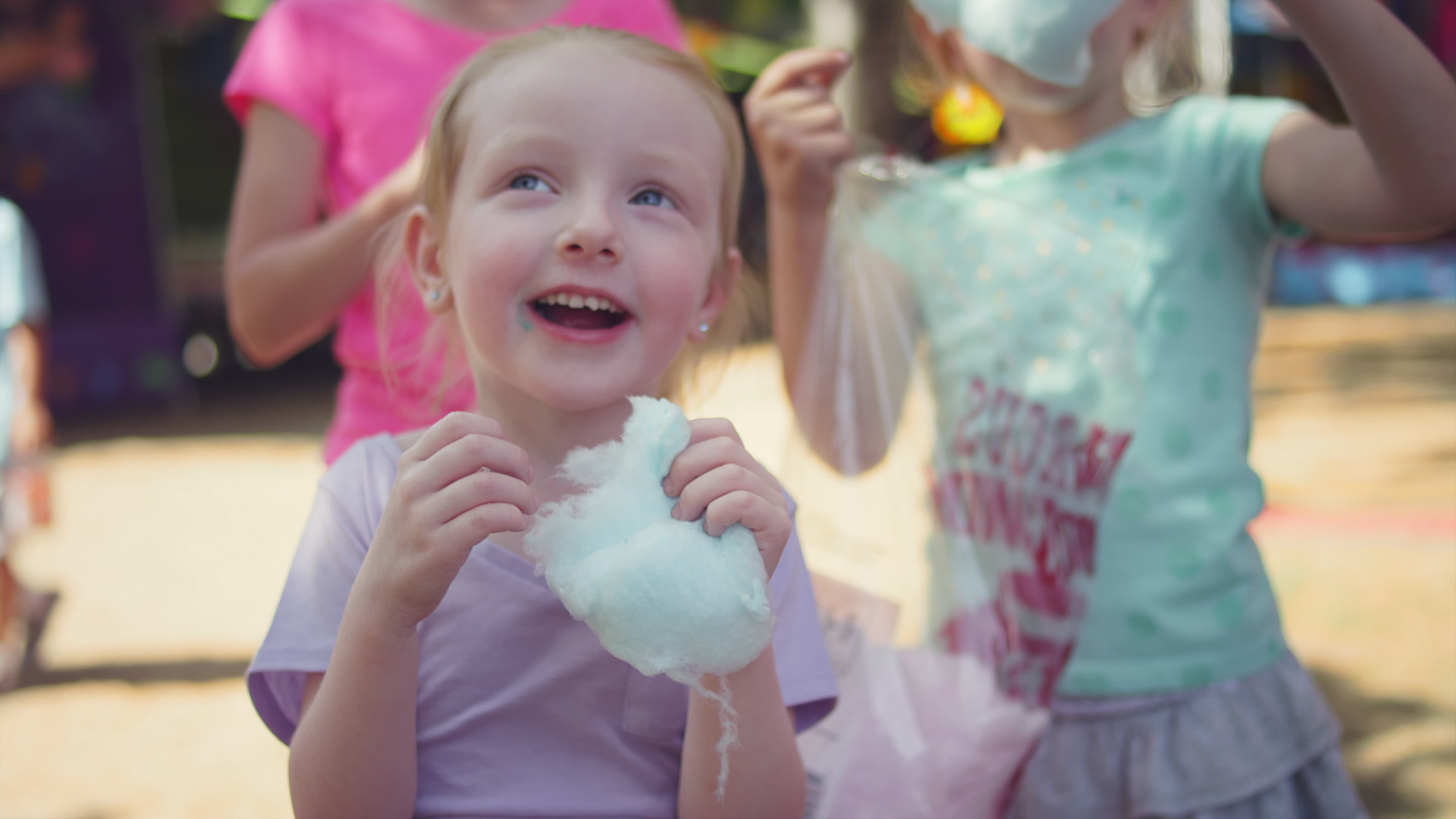 Three little girls eating cotton candy and making funny faces, in slow motion 1281923 Stock