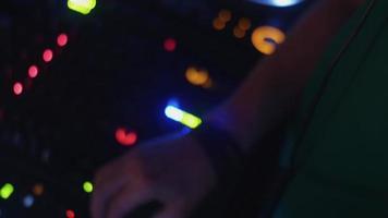DJ tourne à la plaque tournante sur la fête en boîte de nuit. mélange. écouteurs. lumières video