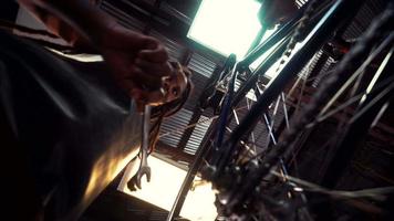 Mecánico de bicicletas afro arreglando una bicicleta en un taller de reparación video