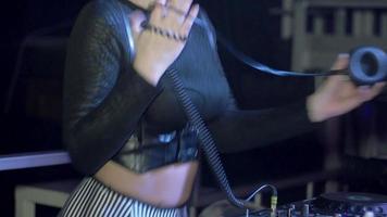 attraktiver DJ-Mädchen sexy Tanz mit Kopfhörern am Plattenteller im Nachtclub