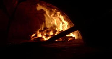 Pizza being placed inside traditional wood fire oven