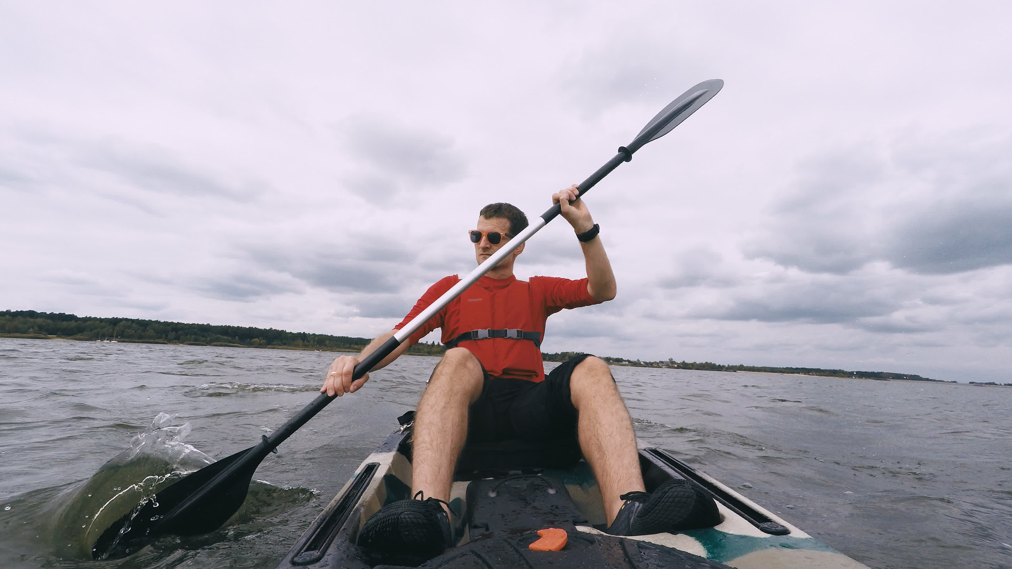 Man kayaking on open water, guy swims in kayak or canoe under dark