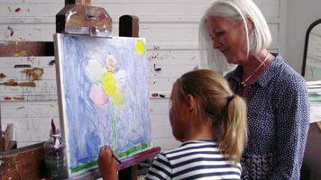 grootmoeder en kleindochter schilderen in studio-opname op r3d video