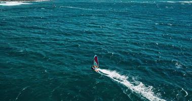 Vista aérea de windsurfista deslizándose por el océano azul video