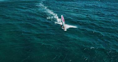 Flygfoto över vindsurfare som glider över det blå havet