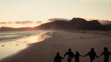 jonge volwassen hipster vrienden genieten van het strand bij zonsondergang video
