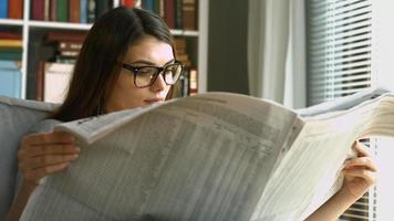 Young woman reading newspaper video