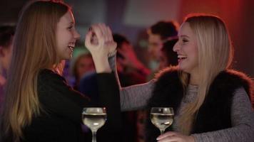 Deux jolies filles au bar en club faisant cinq video