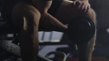 apuesto hombre deportivo en forma está haciendo ejercicio con pesas pesadas en el gimnasio. video
