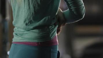 Das sportliche Mädchen mit der attraktiven Passform zieht im Fitnessstudio ihr Sweatshirt aus. video