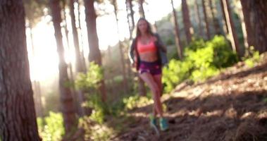 kvinna trail löpare i hoodie leende medan du tar en paus video