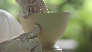 Hände arbeiten an Töpferscheibe und formen eine Keramik video