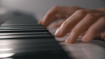 Mano de mujer tocando un sintetizador de teclado controlador midi de cerca.