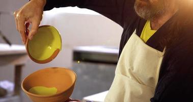 manlig keramiker som häller akvarell i skål video
