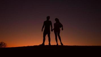 coppia amorosa di sportivi cammina sulle colline di sera.