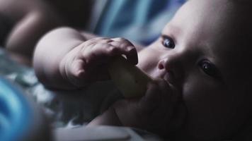 Adorable cute baby sit at children table eating pear. Blue eyes. Look in camera