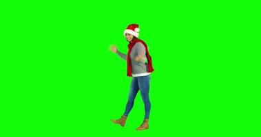 linda morena com chapéu de Papai Noel caminhando e se apresentando com a mão video