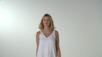 jonge blonde vrouw loopt naar de camera, in focus, en draait video
