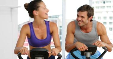 coppia in forma che esercitano sulle bici in studio fitness