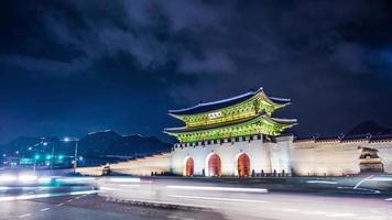 lapso de tiempo del palacio gyeongbokgung y el tráfico por la noche en seúl, corea del sur.