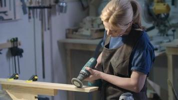 Female carpenter using angle grinder