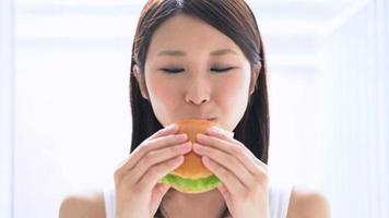 jeune femme, manger, hamburger