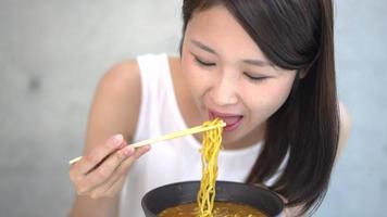 giovane donna che mangia spaghetti ramen