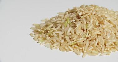 ungekochter brauner Reishaufen, der sich auf Weiß dreht video